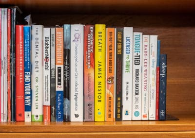 Dr. Phillips's bookshelf with books covering topics on dental, sleep, and airway topics